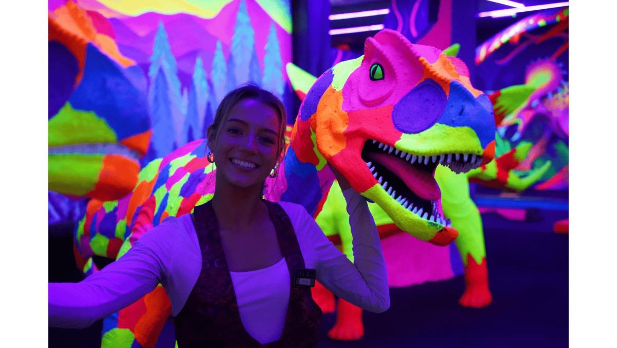 a woman standing in front of a dinosaur exhibit