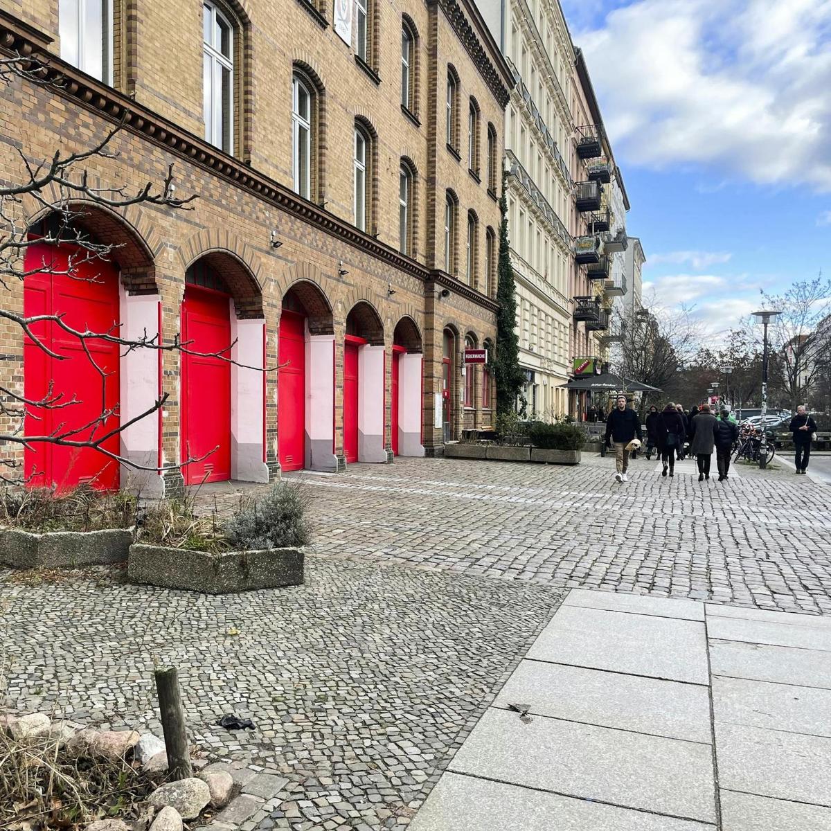 une rue en briques avec des portes rouges sur un bâtiment