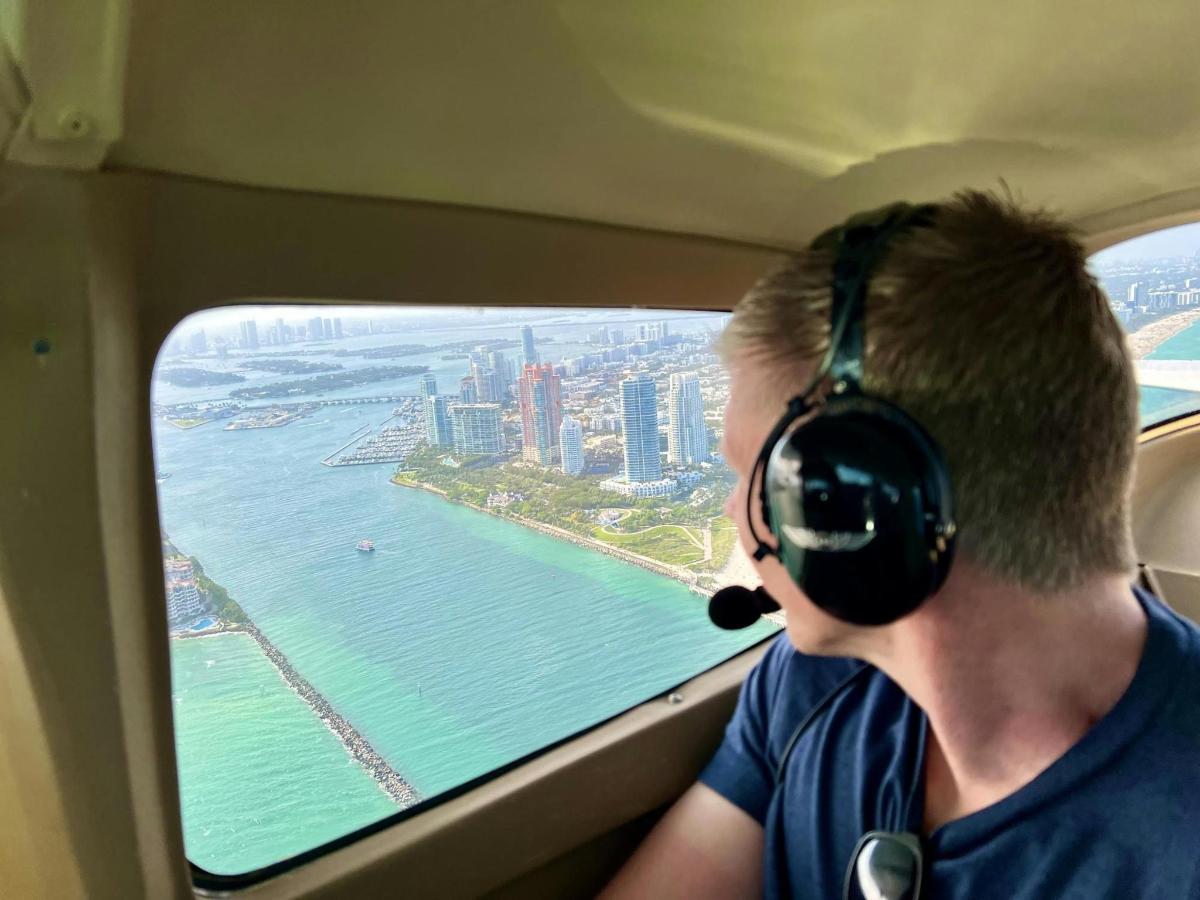 a man wearing headphones looking out the window of an airplane