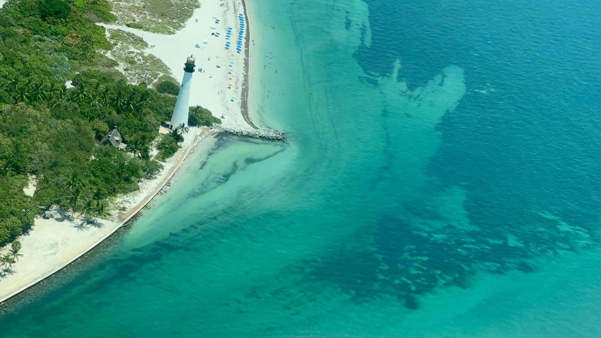 an aerial view of a lighthouse on a beach