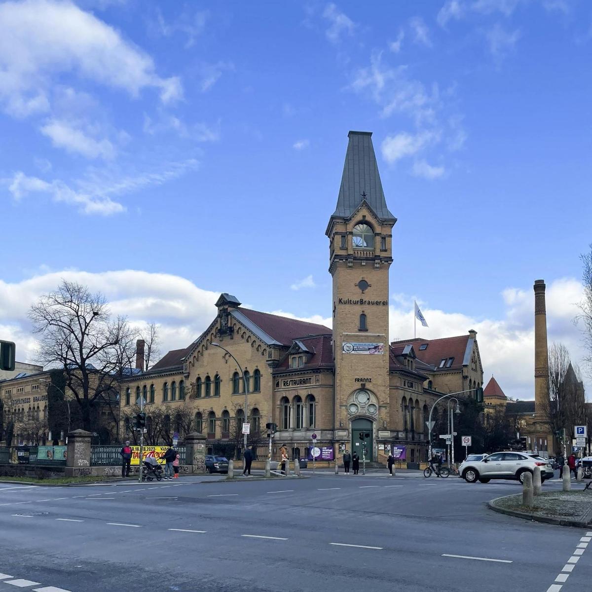 un bâtiment avec une tour d'horloge au milieu d'une rue