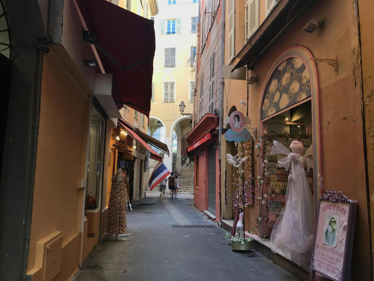 a narrow alley with a dress shop in a city