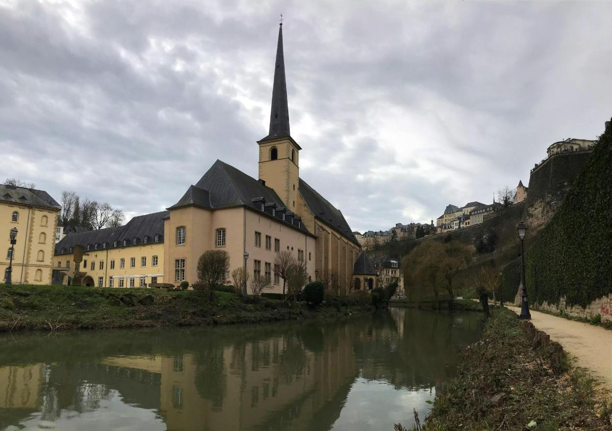 a church with a steeple next to a river