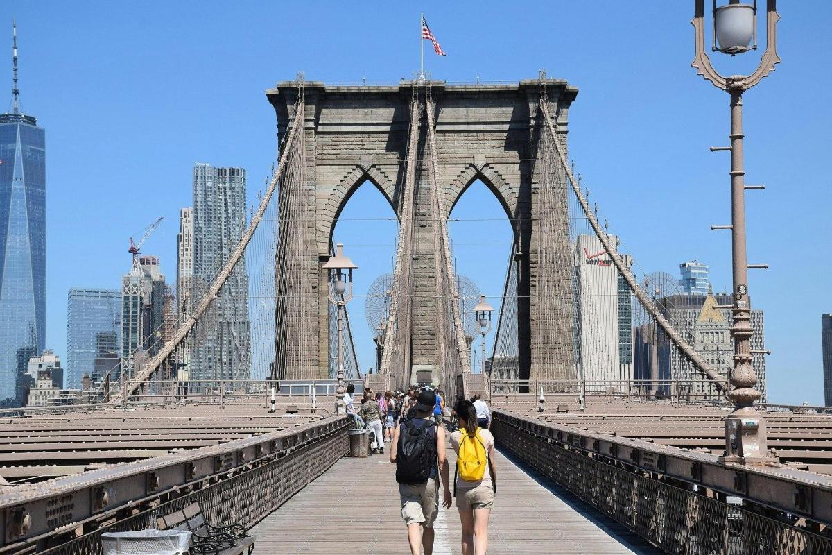 a group of people walking across a bridge