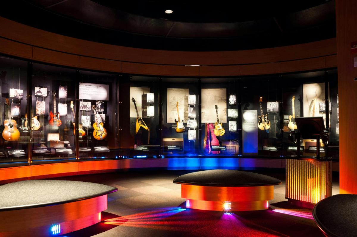 a room with a bunch of guitars on display