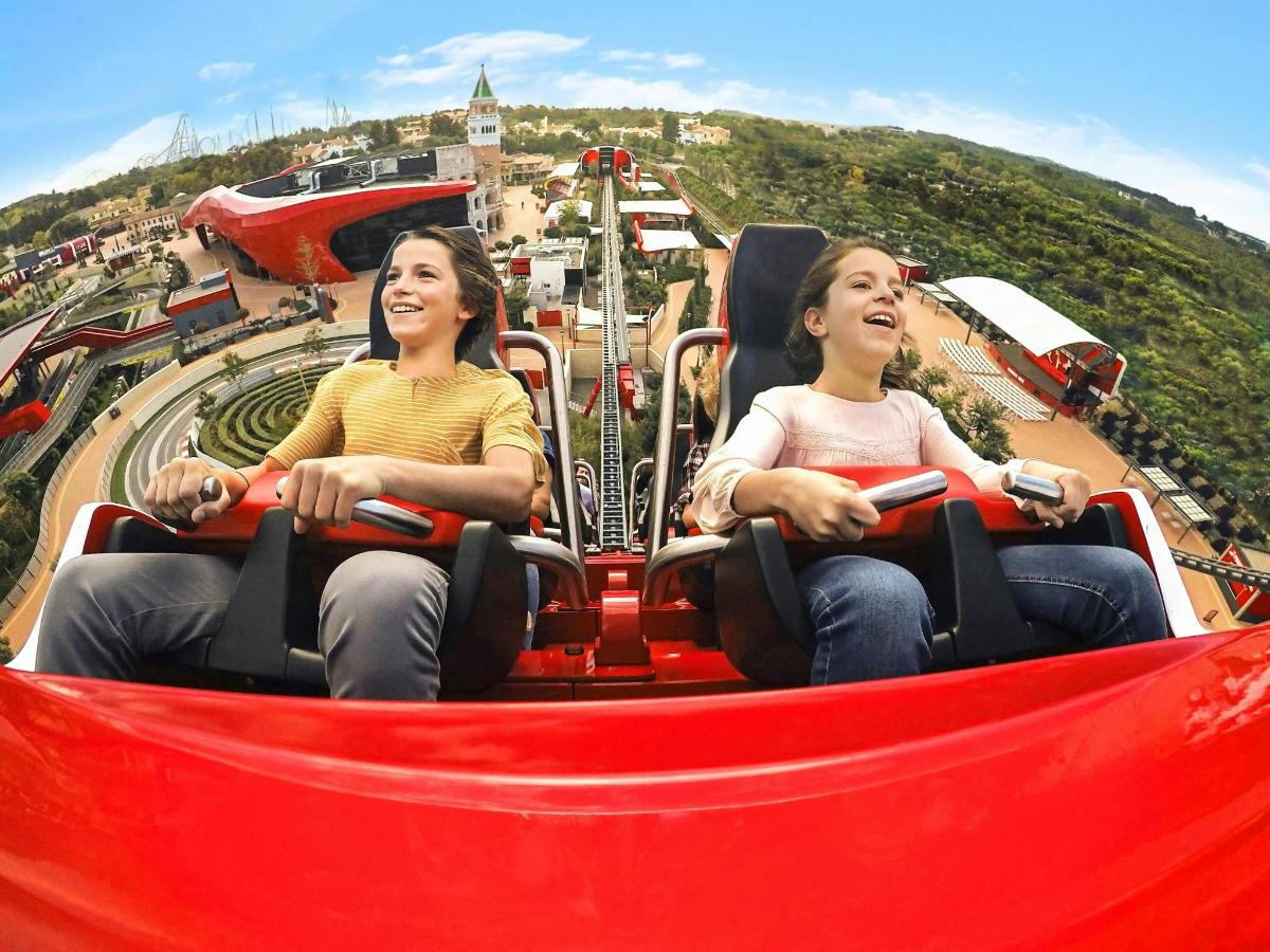 two women riding on a roller coaster at a theme park