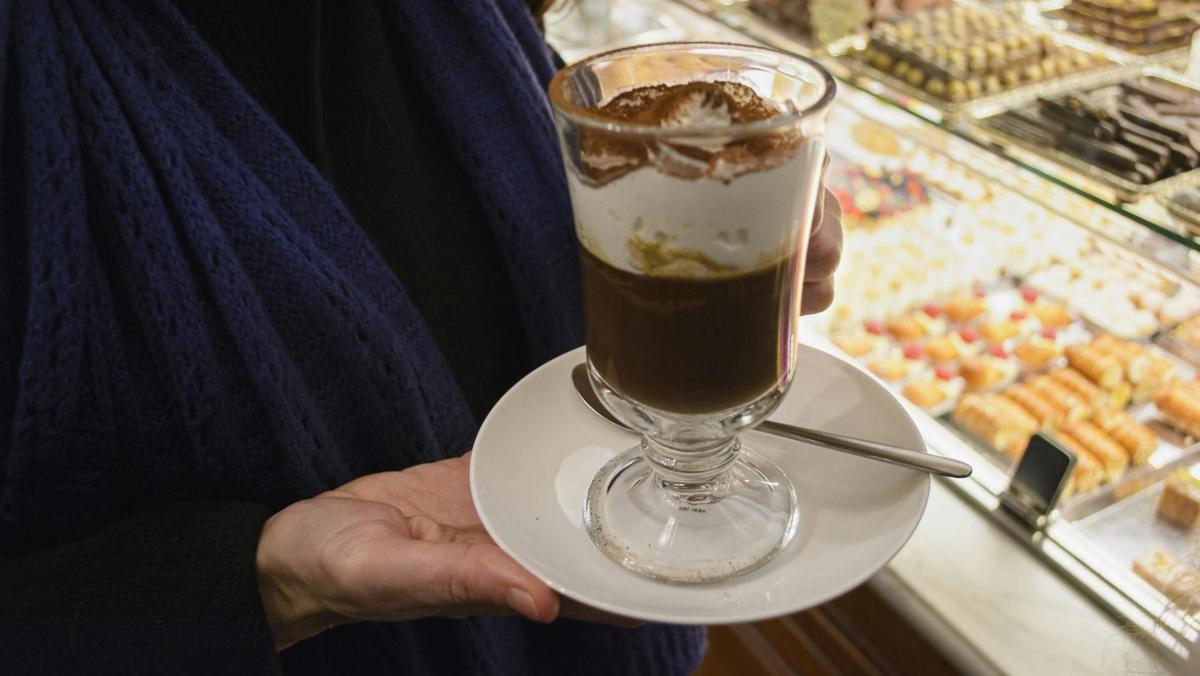 a person holding a drink on a plate