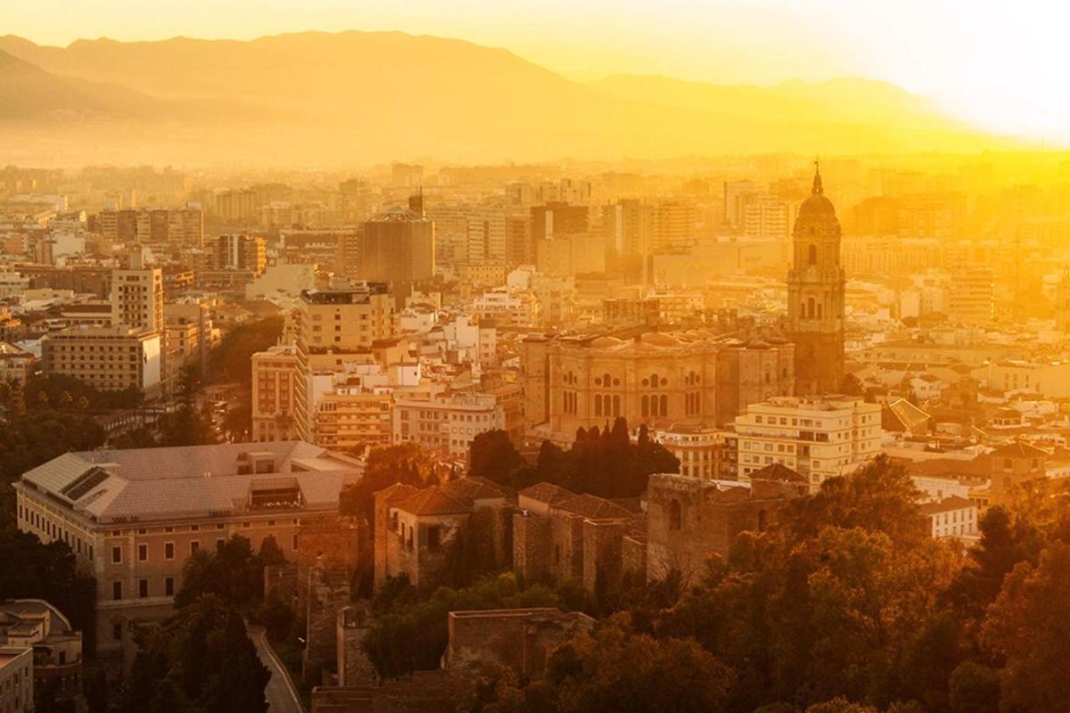 a cityscape of a city with the sun setting