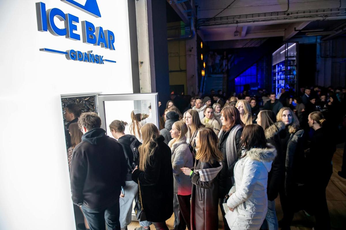 a crowd of people standing in front of a sign
