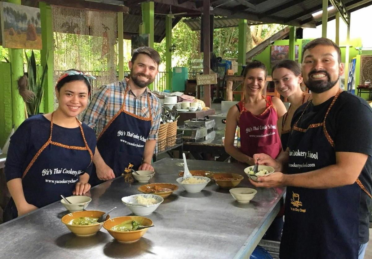 a group of people standing in a kitchen preparing food
