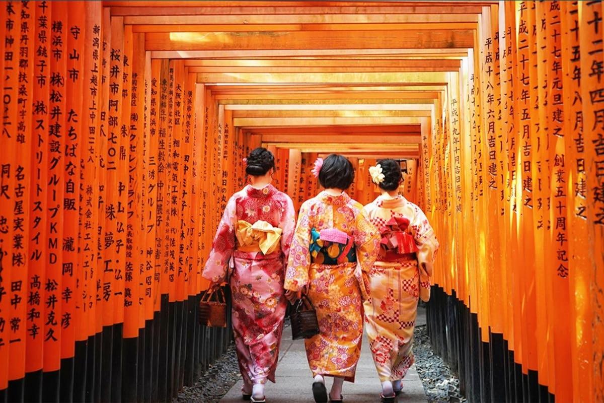 three women walking down a hallway with orange walls
