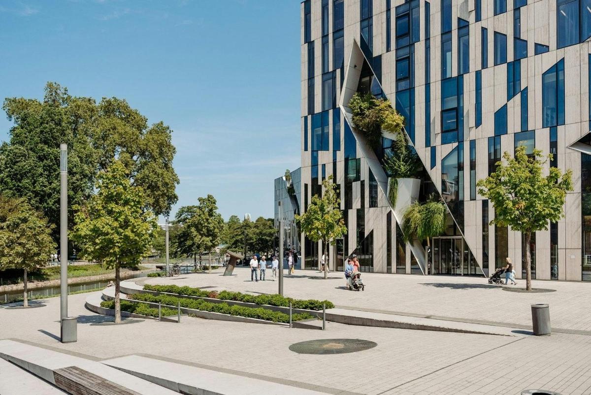 a courtyard in front of a tall glass building