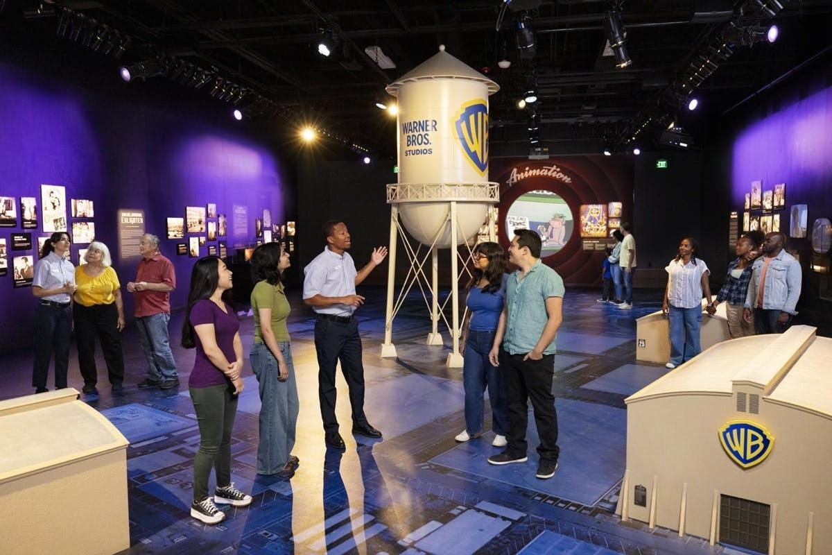 a group of people standing around in a room with a vase