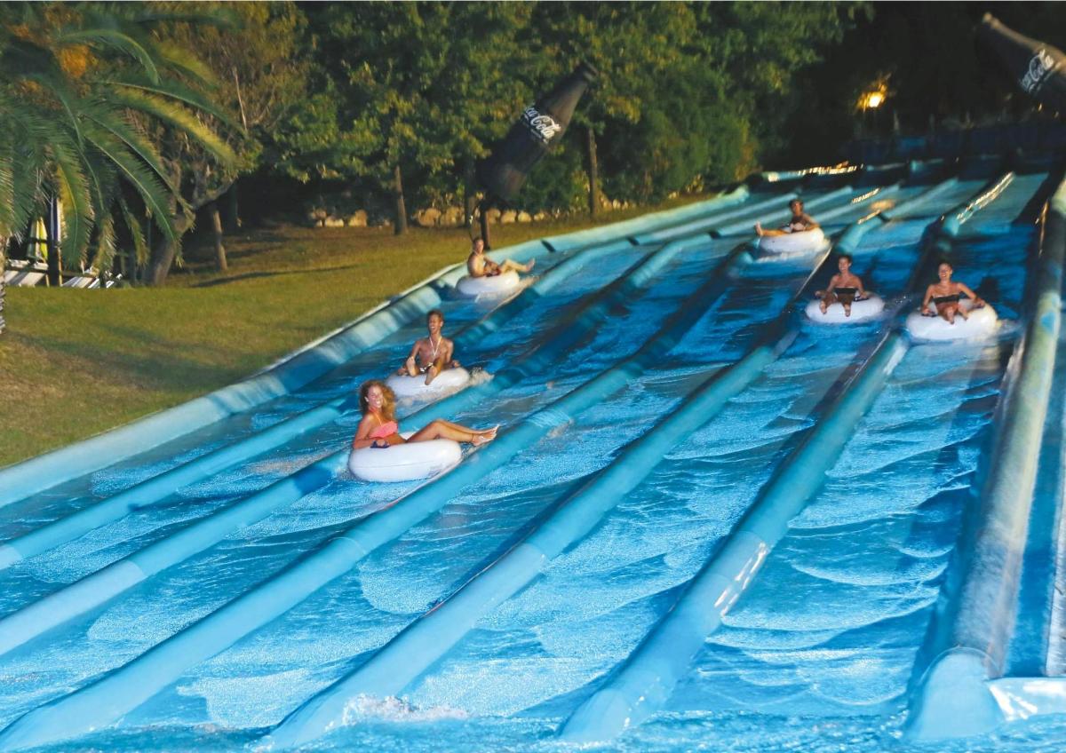 a row of people riding on tubes in a water park