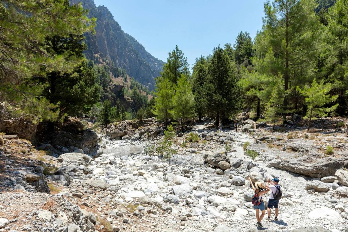 a man and a woman standing on a rocky river