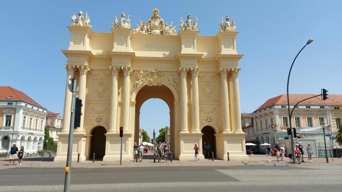 a large building with an arch in the middle of a street
