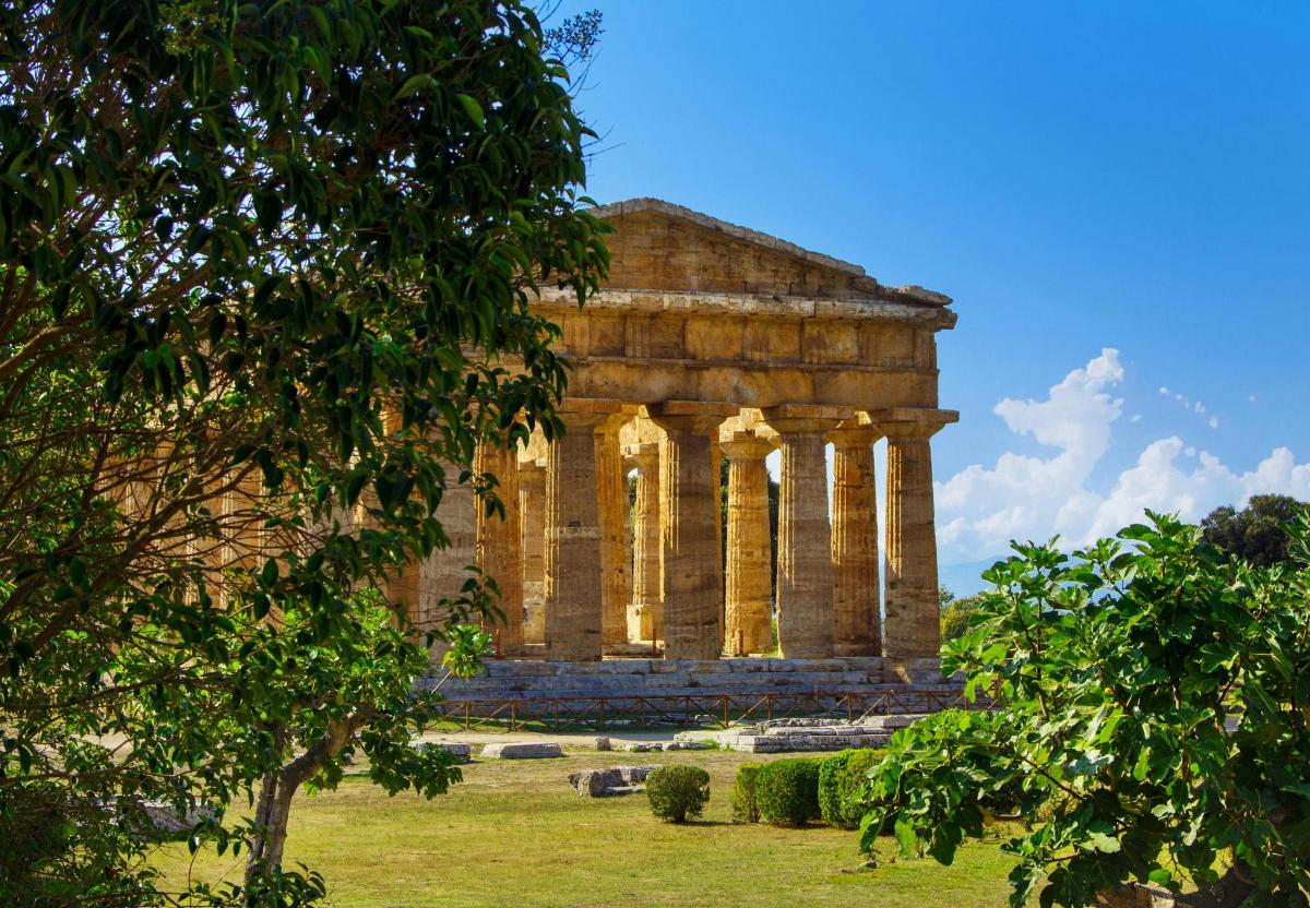an ancient building with columns in a field