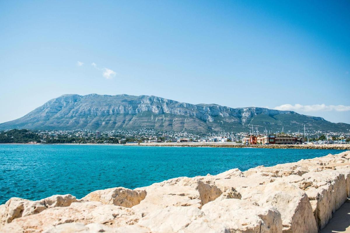 a large body of water with a mountain in the background