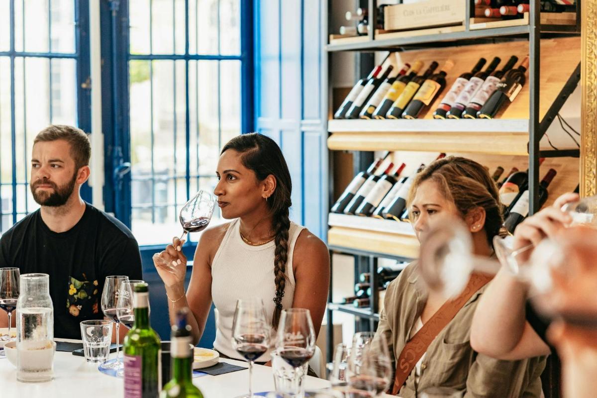 a group of people sitting around a table with wine glasses