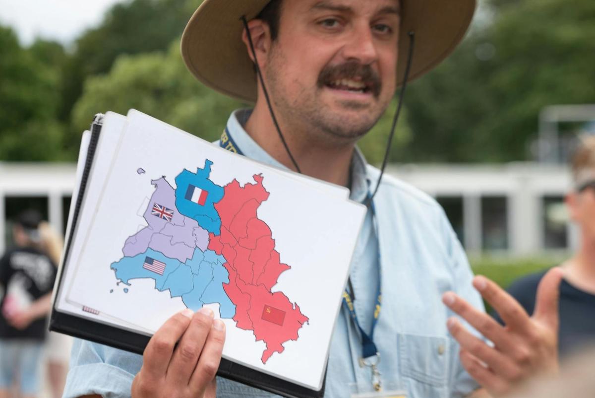 a man wearing a cowboy hat holding a map of ireland