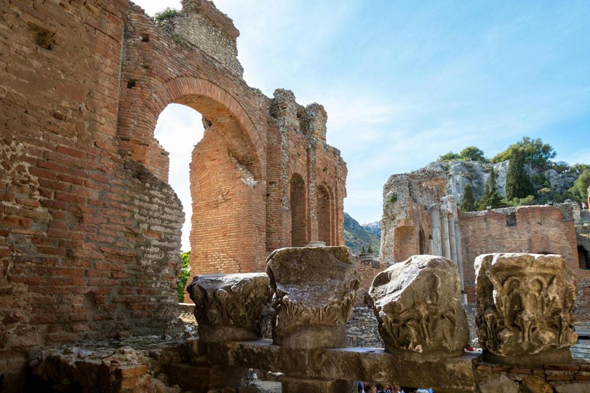 an old brick building with an arch and some rocks