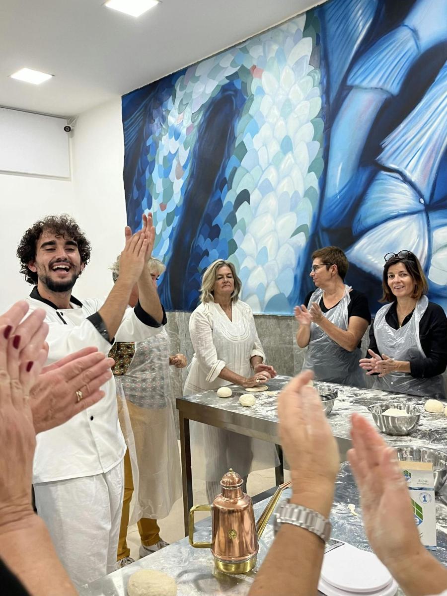 a group of people sitting around a table with their hands up