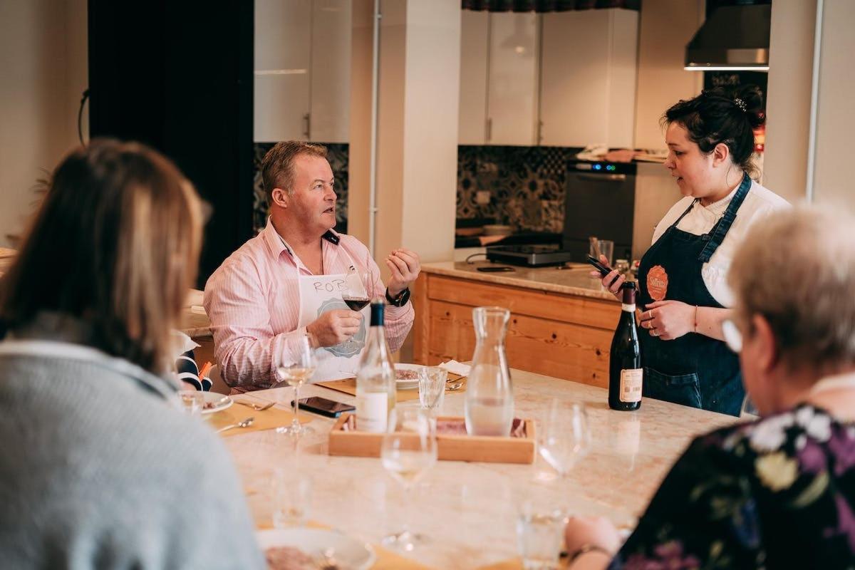 a group of people sitting around a table with wine bottles