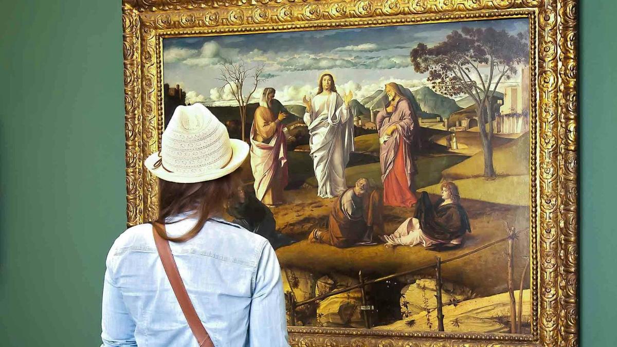 a woman looking at a painting in a museum