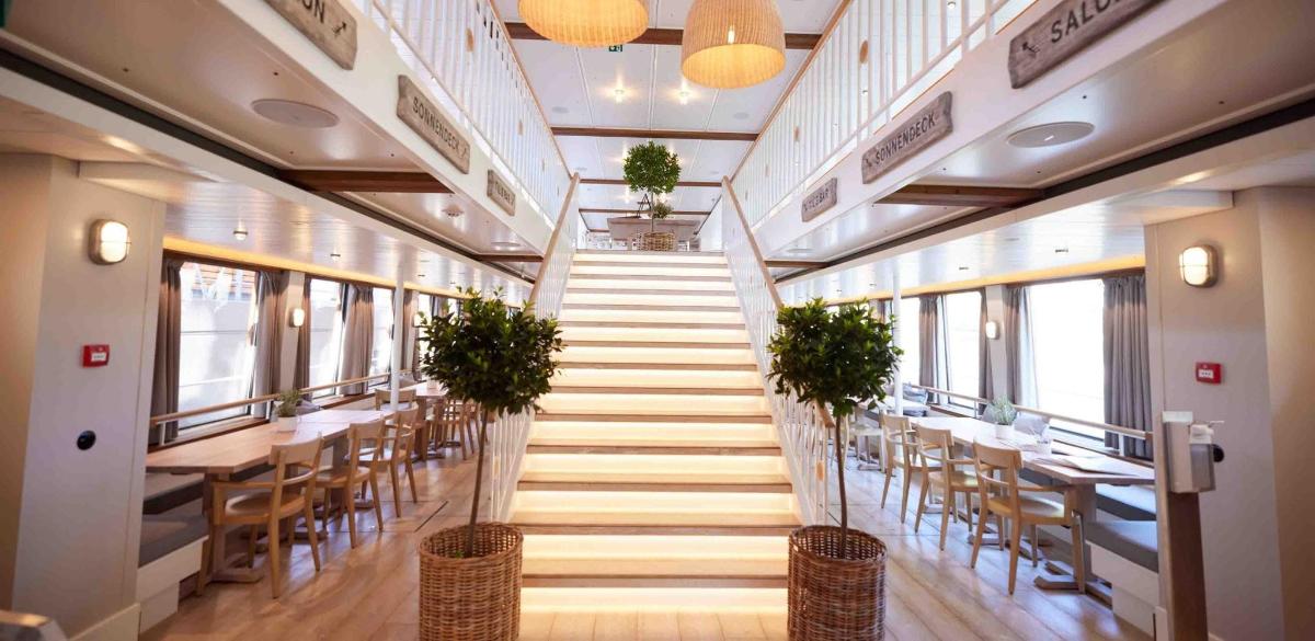 a staircase in a restaurant with tables and chairs
