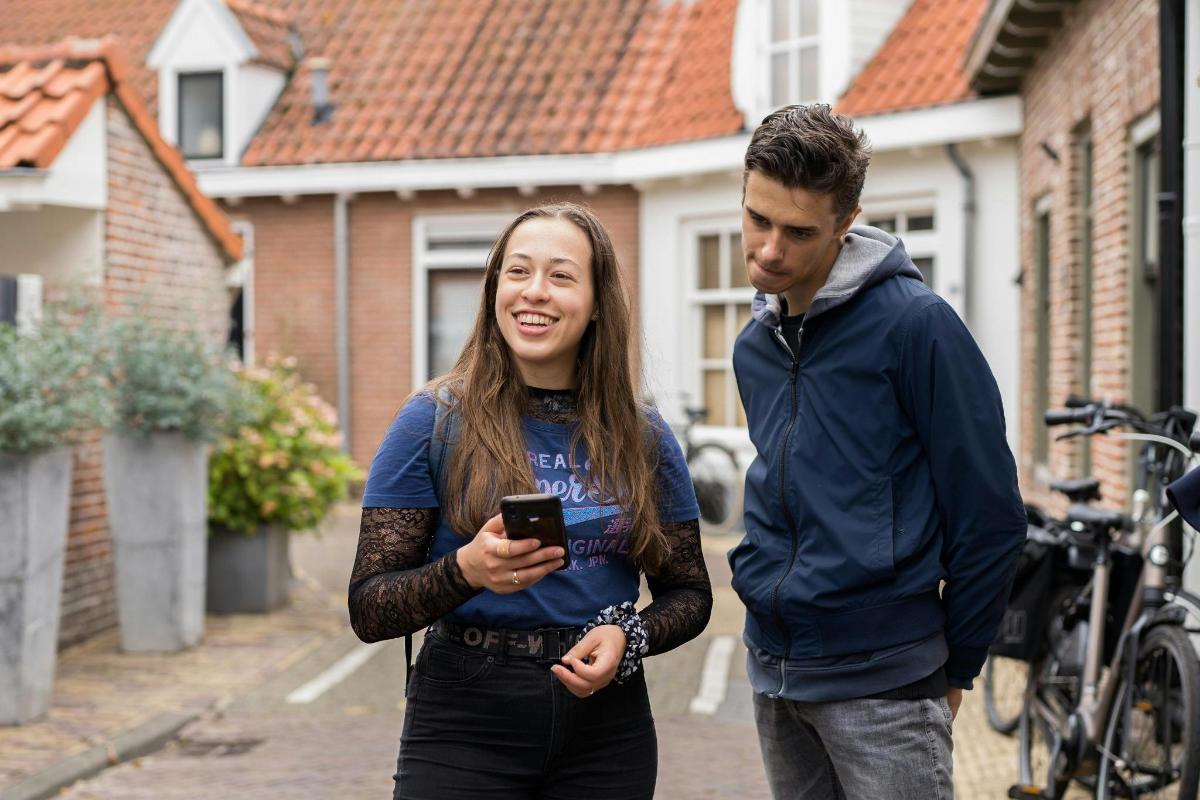 a man and a woman looking at a cell phone