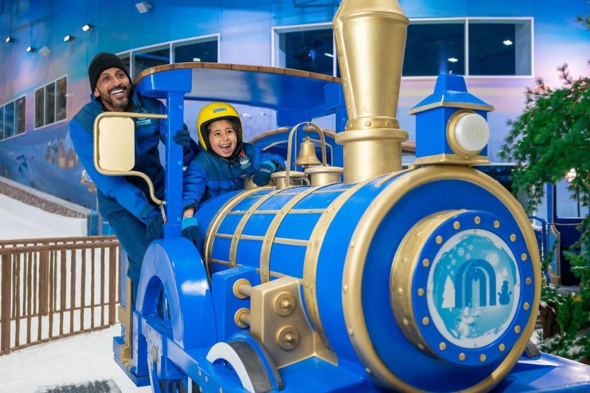a man and a child riding on a toy train