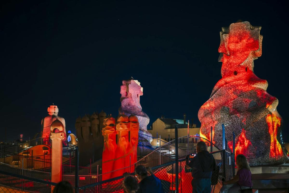 people standing in front of illuminated structures at night