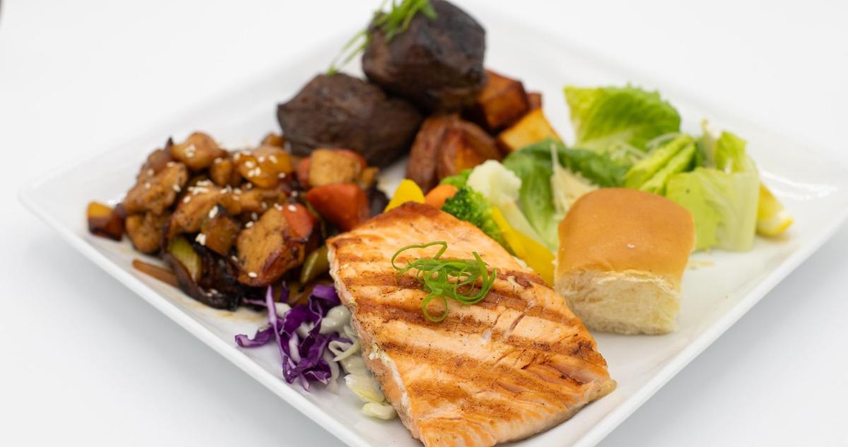 a plate of food with fish and a variety of vegetables