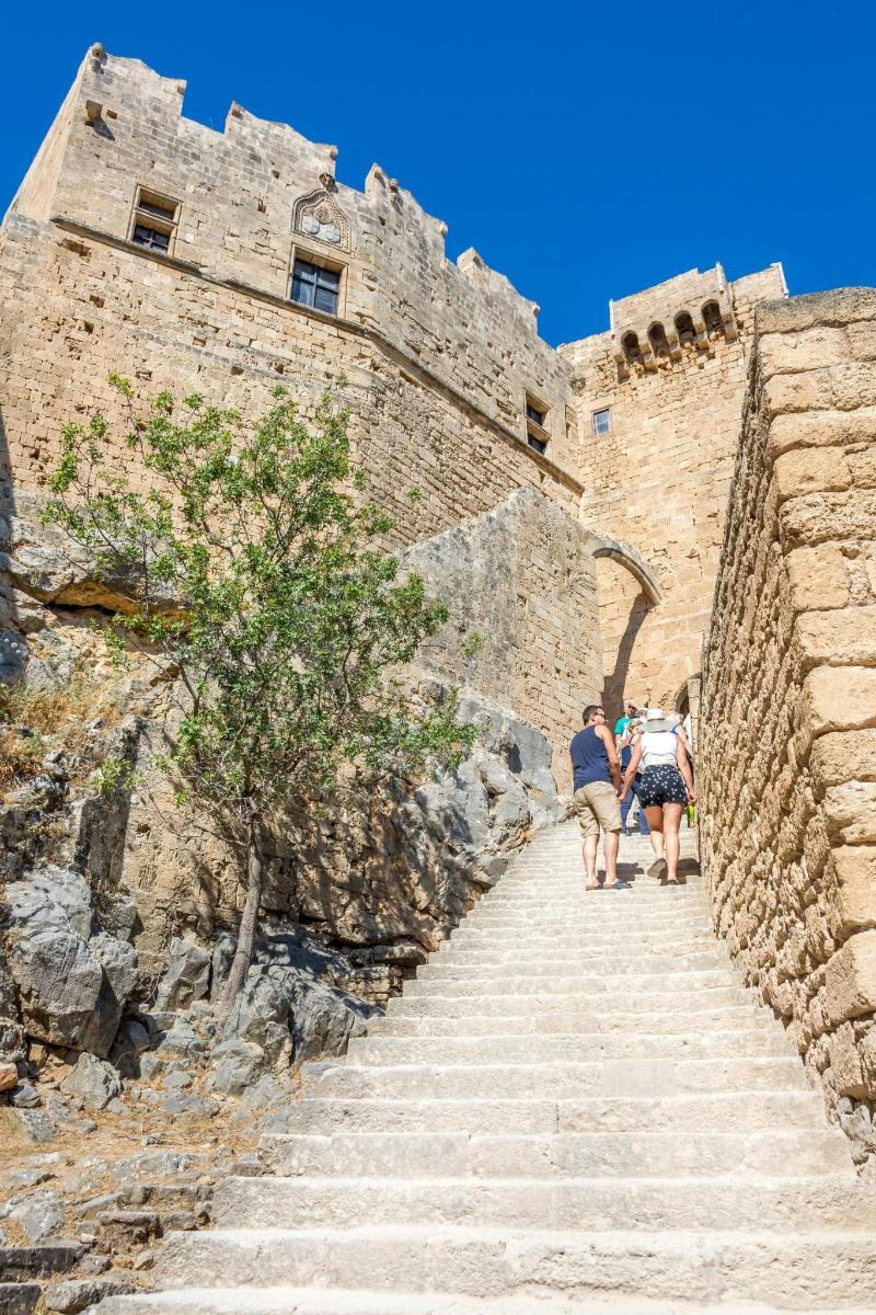 people walking up the stairs of a castle