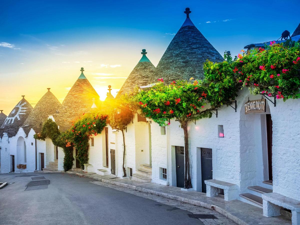 a row of white buildings with flowering trees