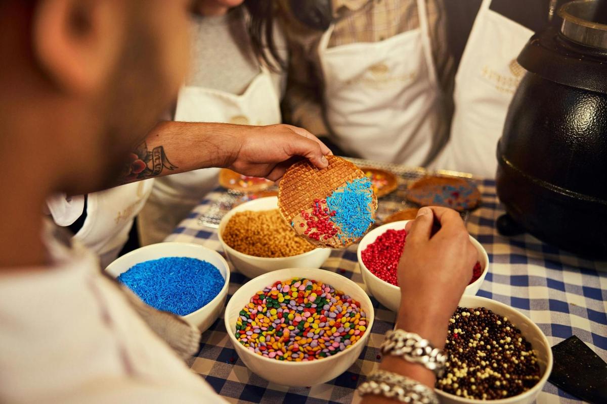 a person putting sprinkles in bowls on a table