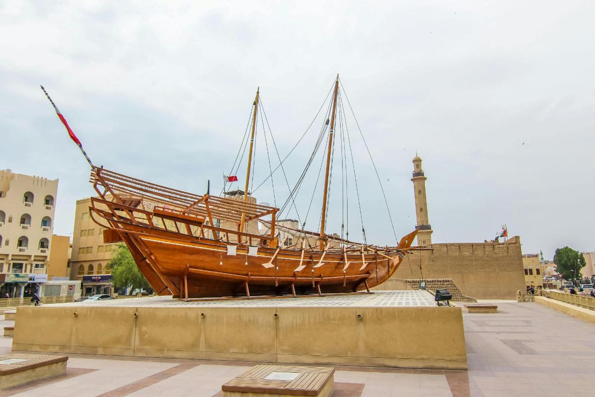 a large wooden boat on display on a sidewalk