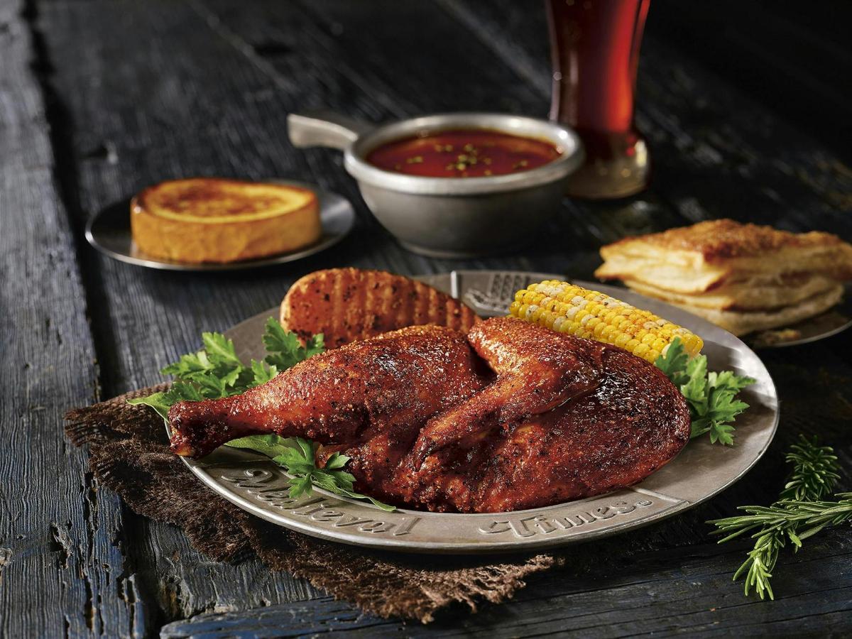 a plate of chicken and corn on a wooden table