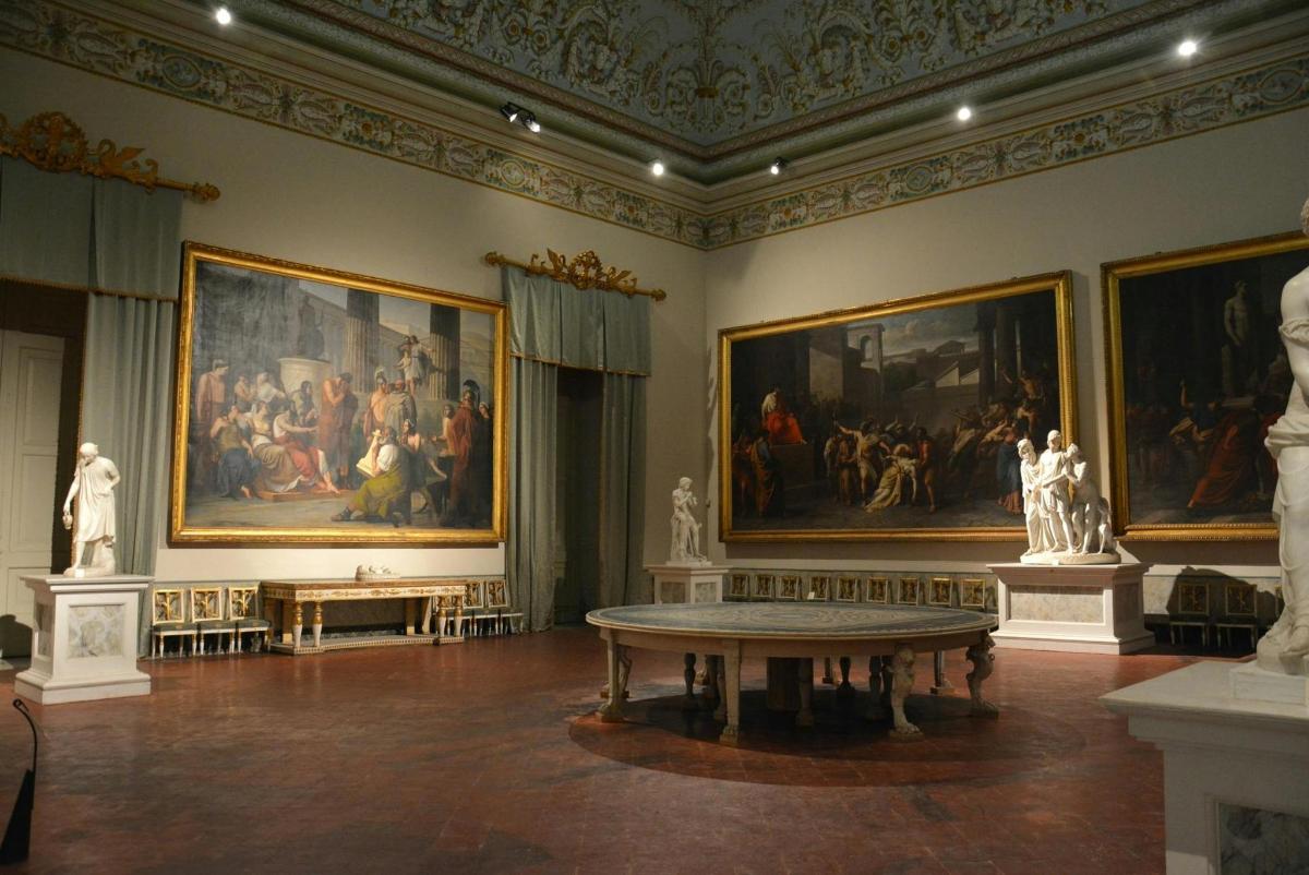 a room with paintings and a table in a museum