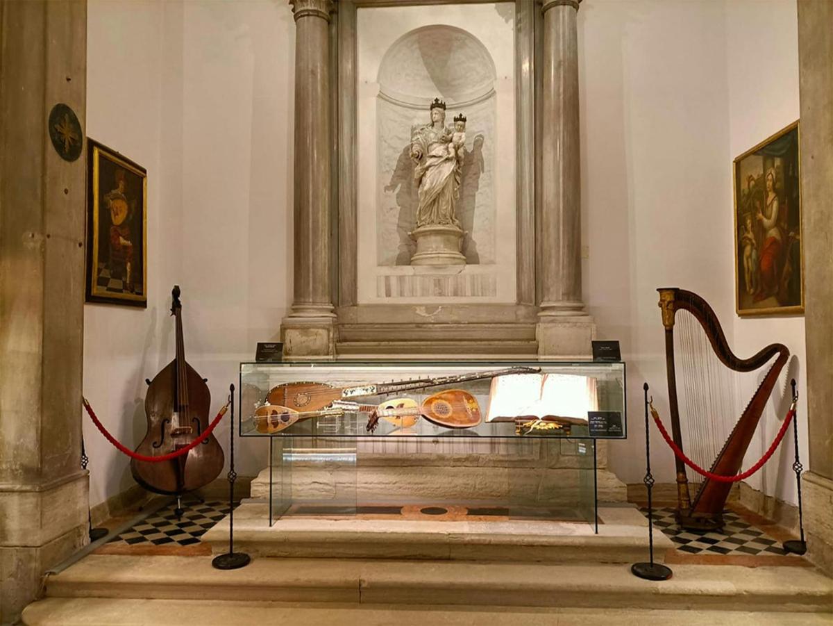 une vitrine dans une pièce avec une statue et un violon