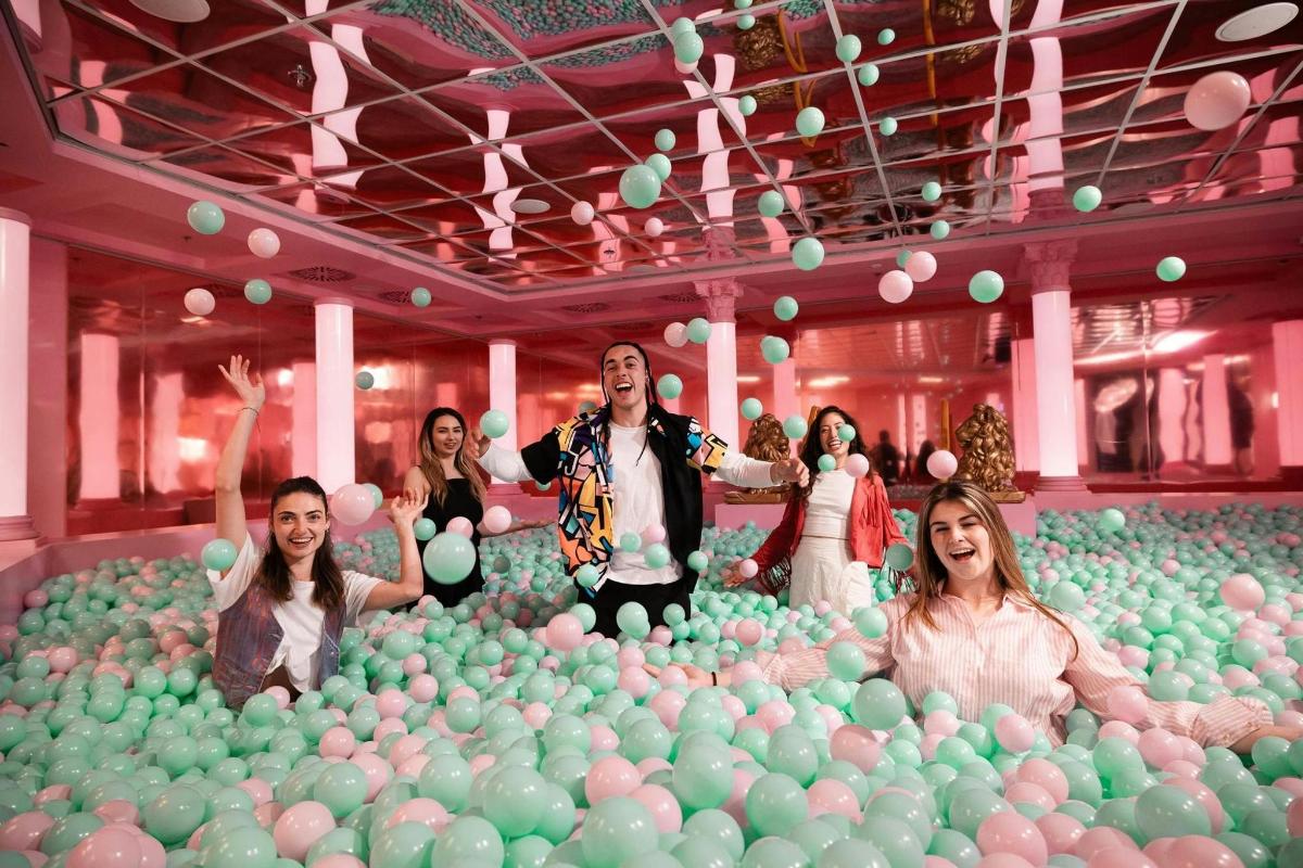 a group of people standing in a room filled with balls