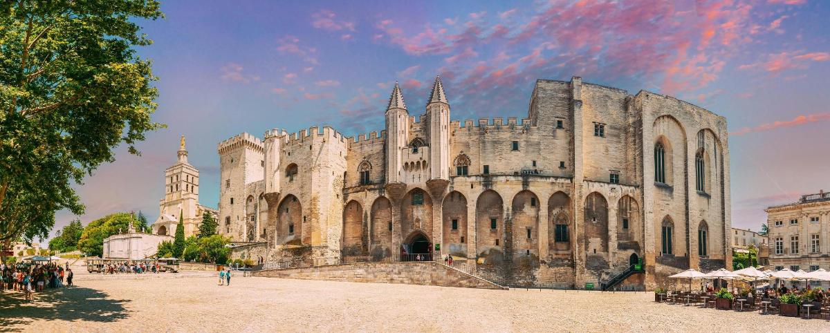 a large stone building with people standing in front of it