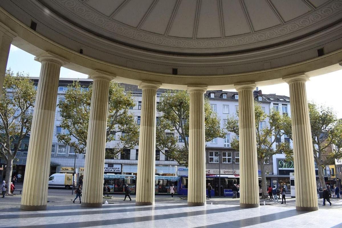 a large building with columns in the middle of a street