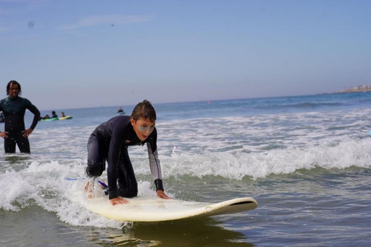 a young boy riding a wave on a surfboard in the ocean