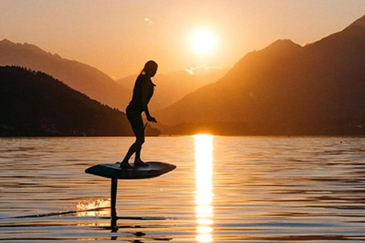 a person on a paddle board in the water at sunset
