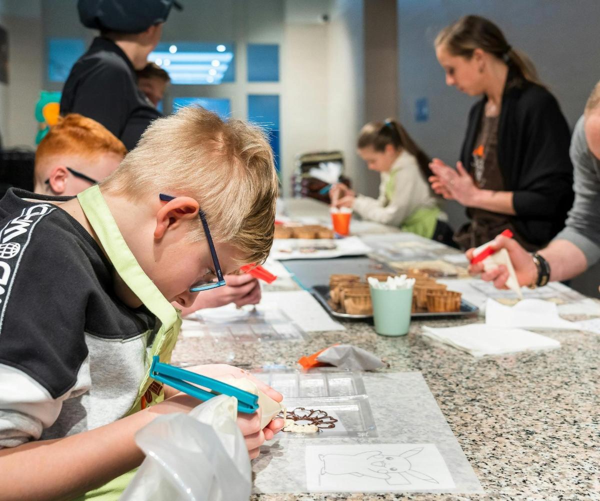 a group of children sitting at a table eating food