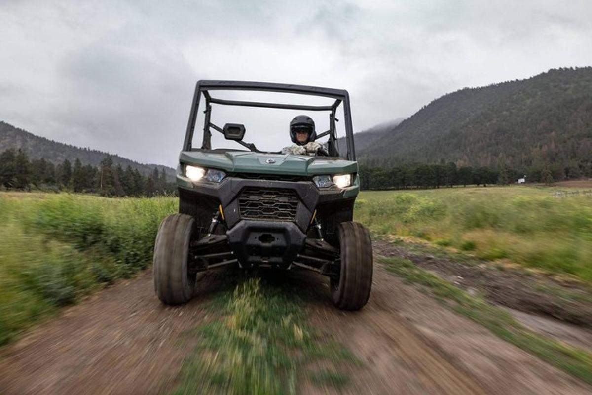 a person in a jeep driving down a dirt road