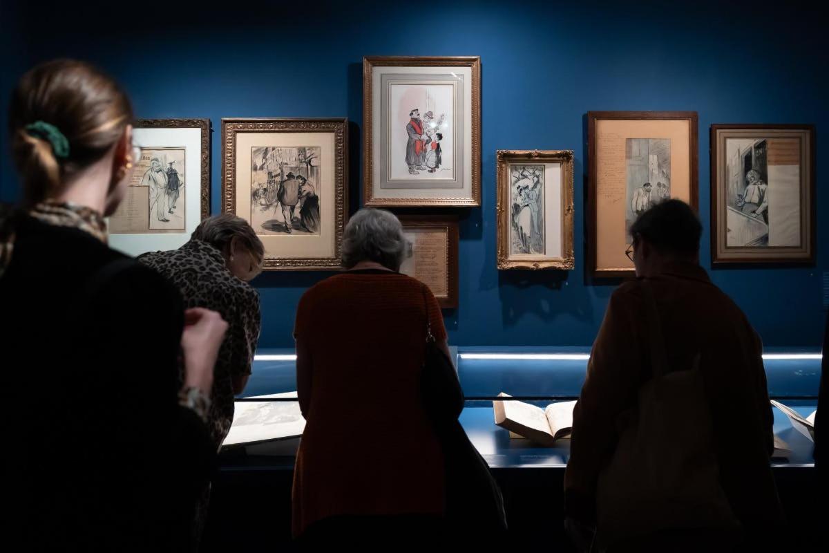 a group of people looking at pictures in a museum