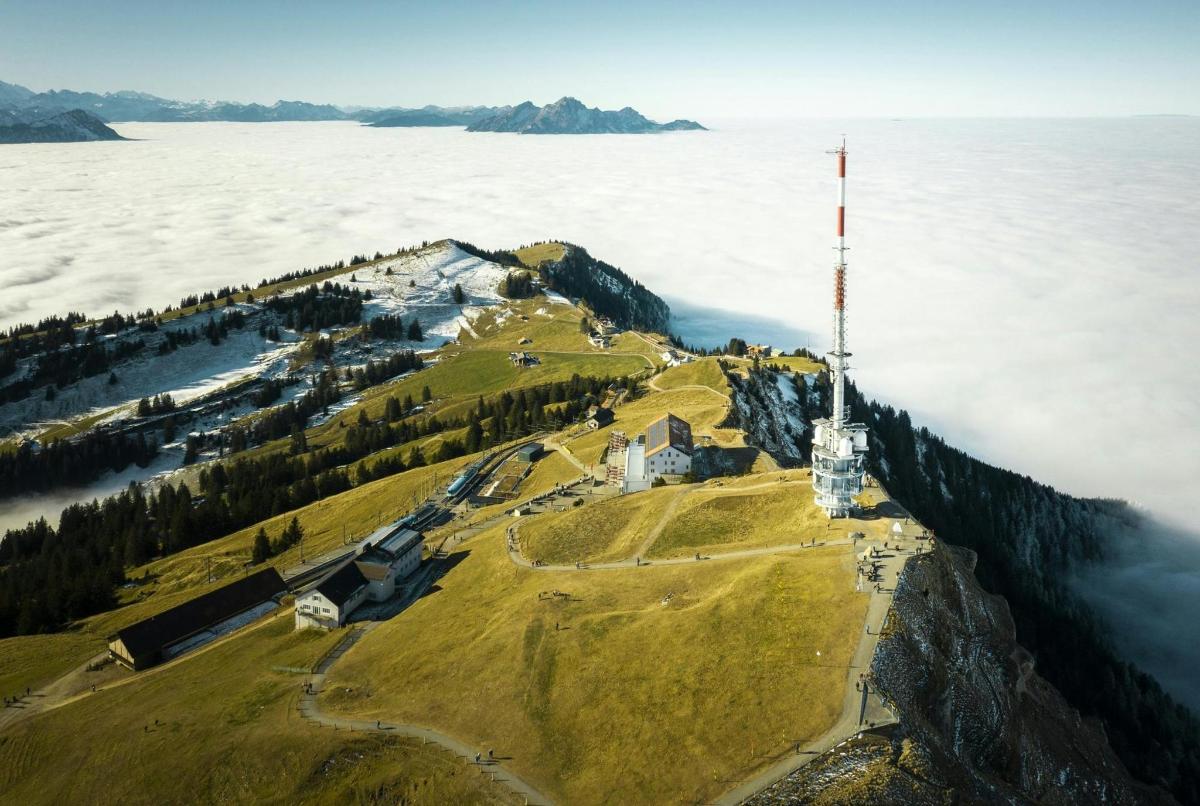 an island in the middle of a body of water with a lighthouse