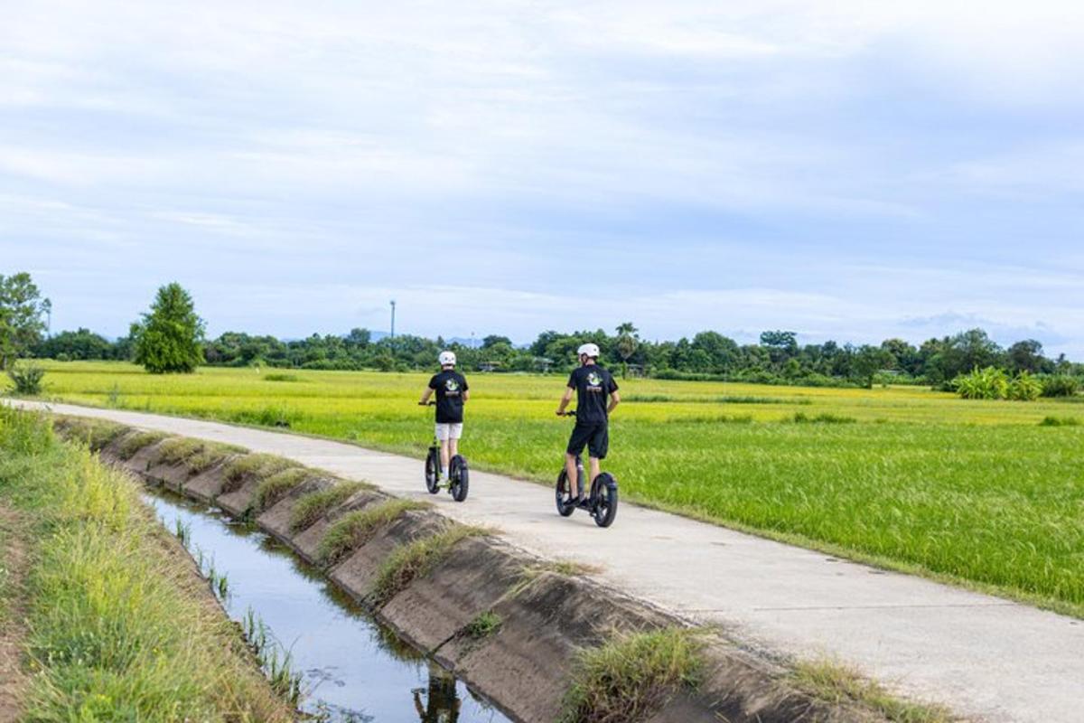 two people riding bikes down a road